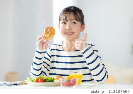 ファミリーイメージ　朝食を食べる女の子 112107666