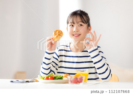 ファミリーイメージ　朝食を食べる女の子 112107668
