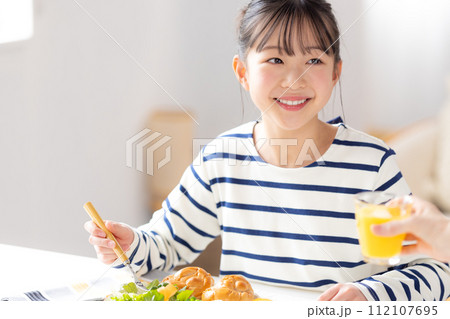 ファミリーイメージ　朝食を食べる女の子 112107695