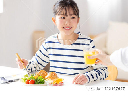 ファミリーイメージ　朝食を食べる女の子 112107697