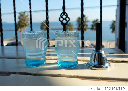 テーブルに置かれた水の入ったグラスとベル 112108519