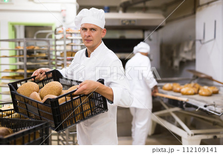 Portrait of baker with fresh bread at bakery Portrait of baker with fresh bread at bakery 112109141