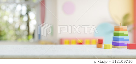 A presentation space on a table features colorful kid's toys in a kid's playroom or nursery. 112109710