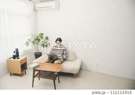 部屋で仕事をする若い男性 部屋で仕事をする若い男性 112112918