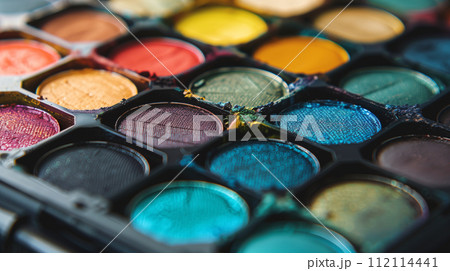 Close-up view of a colorful eyeshadow palette showcasing a variety of vibrant shades and textures 112114441