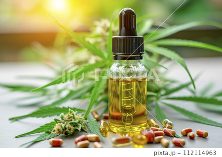 THC tincture and hemp leaves on a table. Concept of herbal alternative medicine, pharmaceutical industry. 112114963