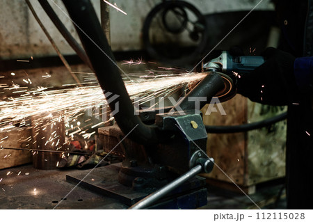 Closeup of unrecognizable man using angle grinder while doing metalwork, copy space Closeup of unrecognizable man using angle grinder while doing metalwork, copy space 112115028