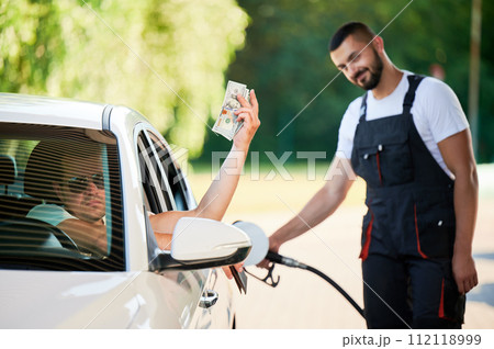 Dissatisfied driver paying a lot of money for gas. Male adult forced to pay twice as much for fuel because of crisis. Price increases due to lack of fuel. 112118999