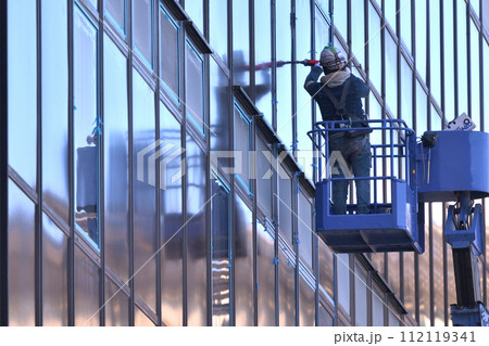 工事現場 高所作業車でシーリング工事の作業風景 工事現場 高所作業車でシーリング工事の作業風景 112119341