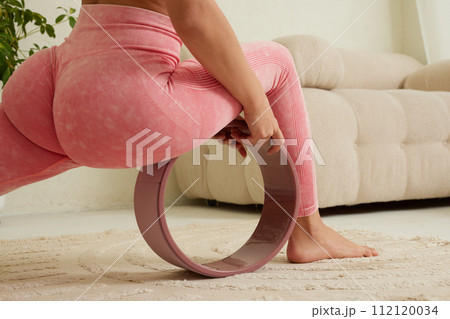 young flexible girl doing gymnastics, flexibility and stretching using a yoga wheel online on a white background young flexible girl doing gymnastics, flexibility and stretching using a yoga wheel online on a white background 112120034