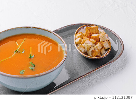 plate of pumpkin cream soup with croutons 112121397
