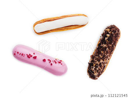 three different types of French eclairs on a white plate isolated on white background 112121545