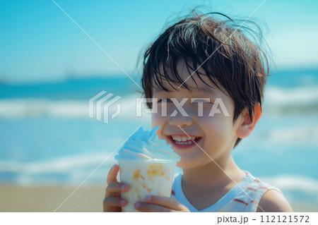 夏の海辺でアイスクリームを食べる男の子 112121572