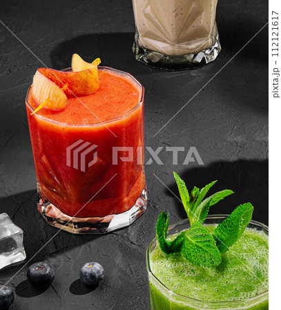 Freshly blended fruit smoothies of various colors and tastes in glass 112121617