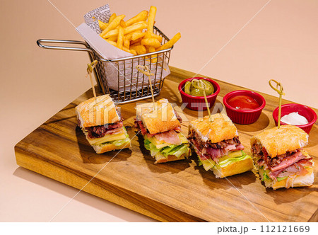Sliced Sandwich and french fries on board Sliced Sandwich and french fries on board 112121669