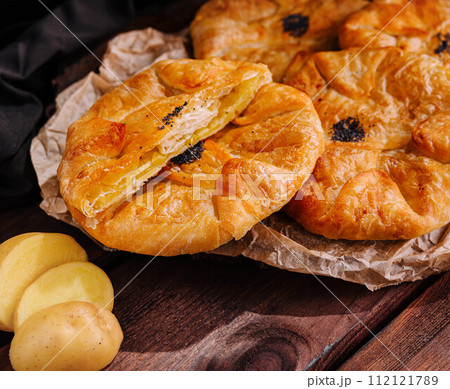 Cooking traditional pies with potatoes on wooden table 112121789