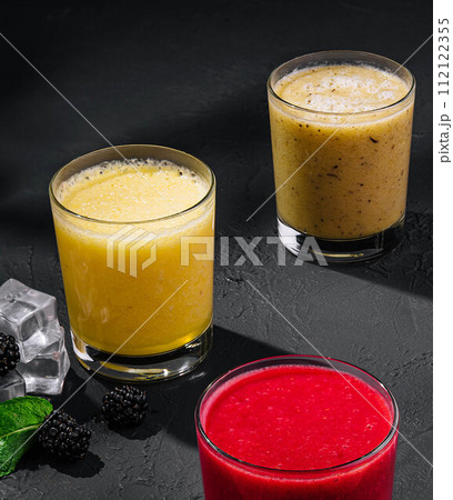 Strawberry, orange and banana smoothies on stone Strawberry, orange and banana smoothies on stone 112122355