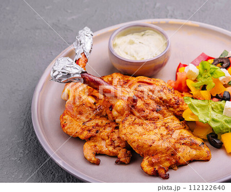 baked golden chicken drumsticks and Greek salad 112122640