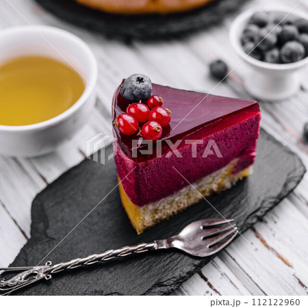 berry mousse cake with red icing and tea 112122960