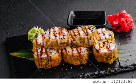 Warm sushi rolls with avocado on black Warm sushi rolls with avocado on black 112123269