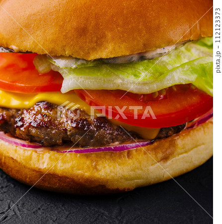 Appetizing cheeseburger on black stone closeup 112123373