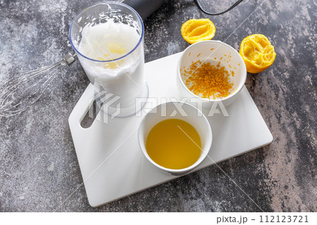 Cooking Glazed easter lemon cake decorated with confectionery and mini chocolate eggs candy on gray stone background, step by step, step 3 112123721