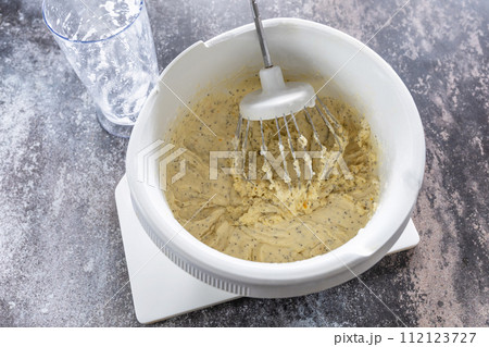 Cooking Glazed easter lemon cake decorated with confectionery and mini chocolate eggs candy on gray stone background, step by step, step 6. 112123727