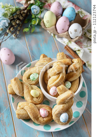 Easter rabbit-shaped buns puff pastry with  cinnamon on a wooden blue tabletop. Copy space. 112123744