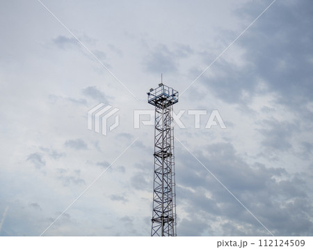 A tower at a strategic facility. Lookout tower. Thin high sentinel point with spotlights A tower at a strategic facility. Lookout tower. Thin high sentinel point with spotlights 112124509