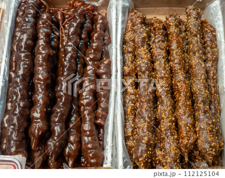 Georgian sweets. Nuts in frozen grape juice on the counter.  churchkhela at the market. Sweet food in assortment. Store in Georgia.  Grape juice sweets 112125104