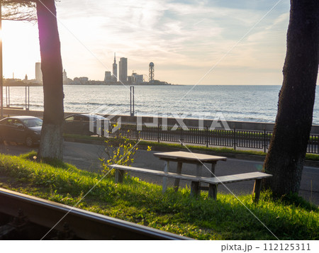 Seats with a table against the backdrop of the sea and the city. Nice place to eat. Sunset over the city. Seats with a table against the backdrop of the sea and the city. Nice place to eat. Sunset over the city. 112125311