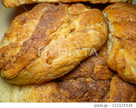 Wicker bun with cinnamon and sugar. Bread product of an unusual shape. Homemade baking. Buns with a ruddy crust. Wicker bun with cinnamon and sugar. Bread product of an unusual shape. Homemade baking. Buns with a ruddy crust. 112125316