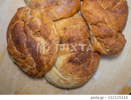 Wicker bun with cinnamon and sugar. Bread product of an unusual shape. Homemade baking. Buns with a ruddy crust. Wicker bun with cinnamon and sugar. Bread product of an unusual shape. Homemade baking. Buns with a ruddy crust. 112125318