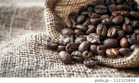 Coffee beans on sackcloth material with shallow depth of field. 112125604