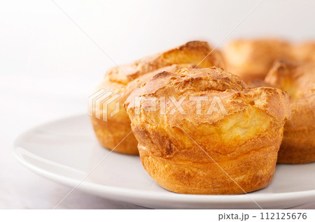 Popovers on white plate on a white background,close up. Yorkshire pudding as a easy cooking breakfast, tasty food, light snack Popovers on white plate on a white background,close up. Yorkshire pudding as a easy cooking breakfast, tasty food, light snack 112125676