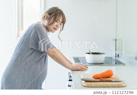 妊娠中にキッチンで調理中に体調不良になる女性（陣痛・腹痛・辛い） 112127296