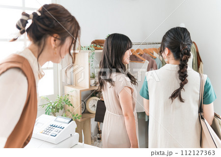 アパレルショップ・雑貨屋で買い物をして帰る女性客とお見送りする女性ショップ店員 112127363