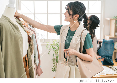 アパレルショップで洋服を買い物・ショッピングする女性 112127377