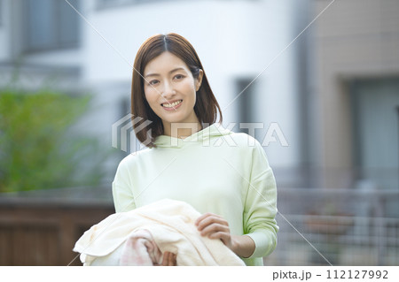 洗濯物を持つミドルの女性 洗濯物を持つミドルの女性 112127992