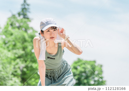 公園でランニング・ジョギング中にタオルで汗を拭く若いアジア人女性 112128166
