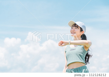 青空の下でスマートウォッチを見ながら健康管理をする女性(消費カロリー・ダイエット・ウォーキング) 青空の下でスマートウォッチを見ながら健康管理をする女性(消費カロリー・ダイエット・ウォーキング) 112128212