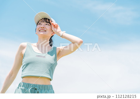 健康・ダイエットのため公園で運動をする女性(汗・紫外線対策・日光浴) 112128215