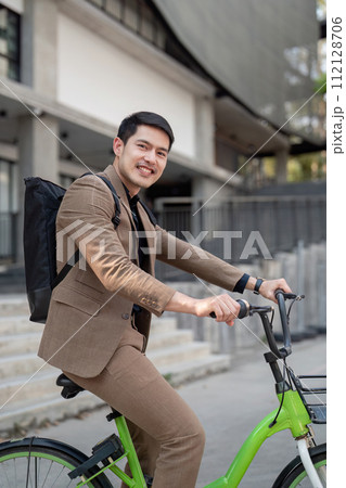 The businessman eco friendly transportation, cycling through the city avenues to go to work. sustainable lifestyle concept 112128706
