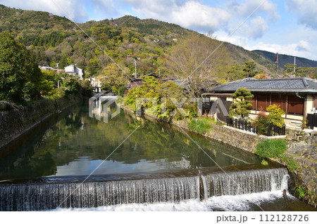 日本の春の京都 嵐山周辺の街並み 観光名所の桂川と満開の桜と美しい新緑 川沿いの古い住居 日本の春の京都 嵐山周辺の街並み 観光名所の桂川と満開の桜と美しい新緑 川沿いの古い住居 112128726