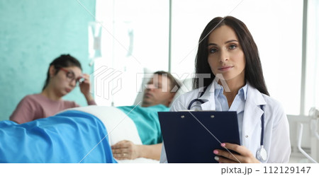 Doctor with folder is standing in palette sick man 112129147