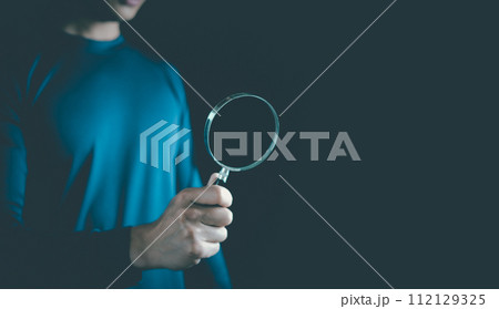 Man use hand lens glass magnifier search for best option on black background. Discover, find, inspector, team, Data Search, Search for information, Marketing, Human Resource Management HRM concept Man use hand lens glass magnifier search for best option on black background. Discover, find, inspector, team, Data Search, Search for information, Marketing, Human Resource Management HRM concept 112129325