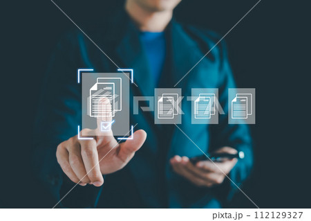E-document management, Businessman touching on document for online approve paperless quality assurance and ERP management concept. Online documentation database, paperless office concept. E-document management, Businessman touching on document for online approve paperless quality assurance and ERP management concept. Online documentation database, paperless office concept. 112129327