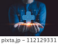 Healthcare insurance and medicine concept. Businessman holding virtual blue plus sign for positive thinking mindset or healthcare insurance symbol, Mental health care, mental rejuvenation. 112129331