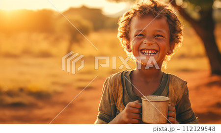 Poor, beggar, hungry Caucasian child boy in Africa, thirsty to drink water. 112129548