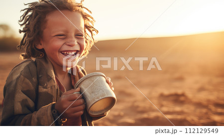 Poor, beggar, hungry black child boy in Africa, thirsty to drink water. 112129549